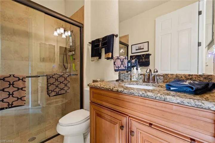 Full bathroom featuring vanity, toilet, and a stall shower