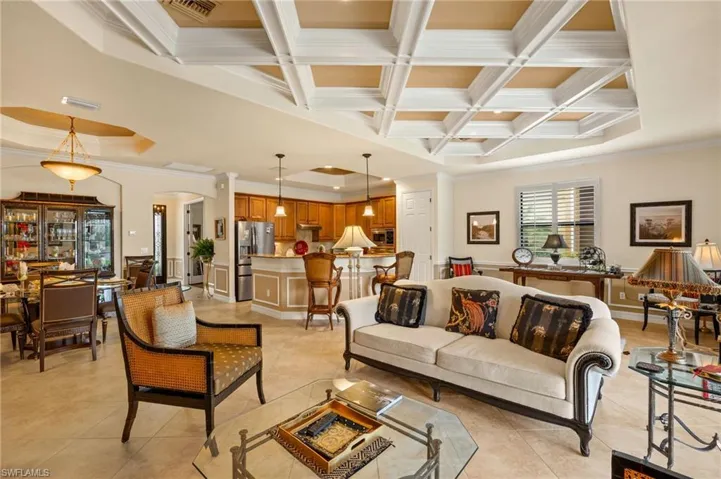 Living area featuring beam ceiling, light tile patterned floors, and coffered ceiling
