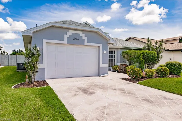 Ranch-style home featuring central AC unit, a garage, and a front yard