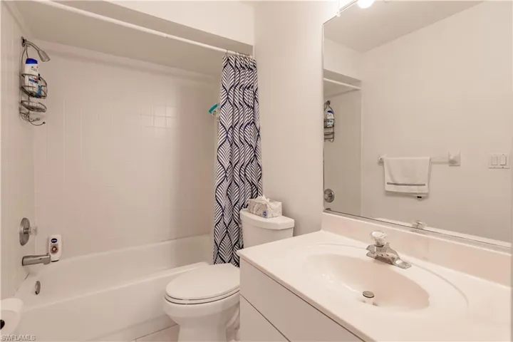 Full bathroom with shower / bath combination with curtain, toilet, and vanity