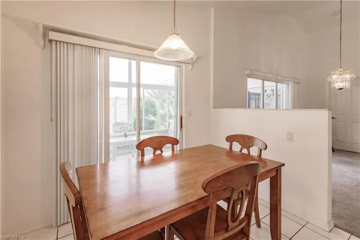 Tiled dining area with an inviting chandelier and lofted ceiling
