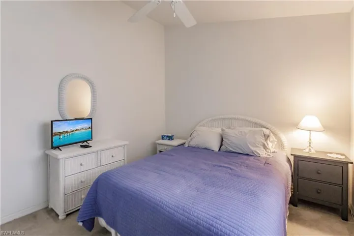 Carpeted bedroom featuring ceiling fan