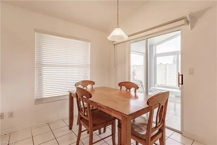 Tiled dining space featuring lofted ceiling and plenty of natural light