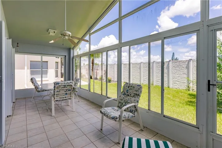 Sunroom featuring a water view, vaulted ceiling, and ceiling fan