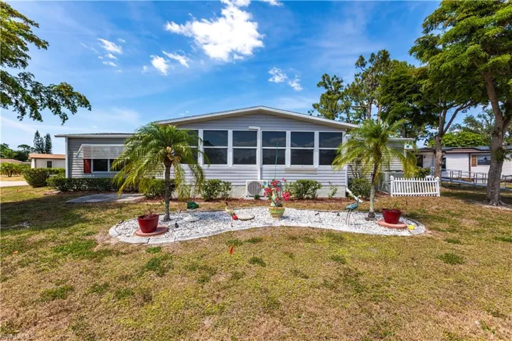 View of front of property with a front lawn, a sunroom, and fence