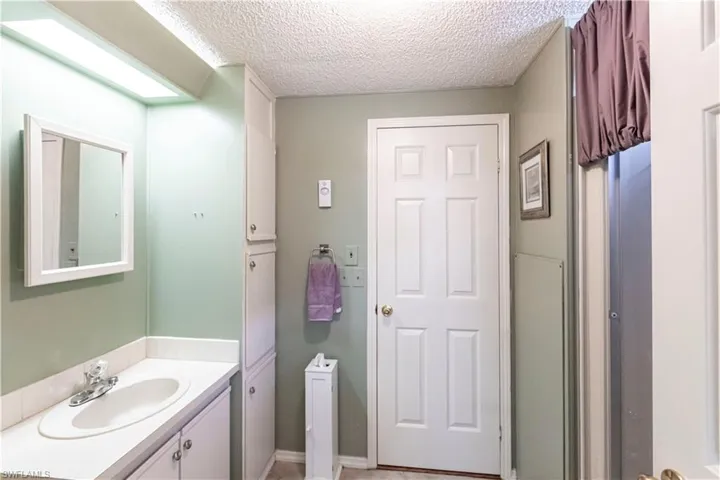 Bathroom featuring a textured ceiling and vanity