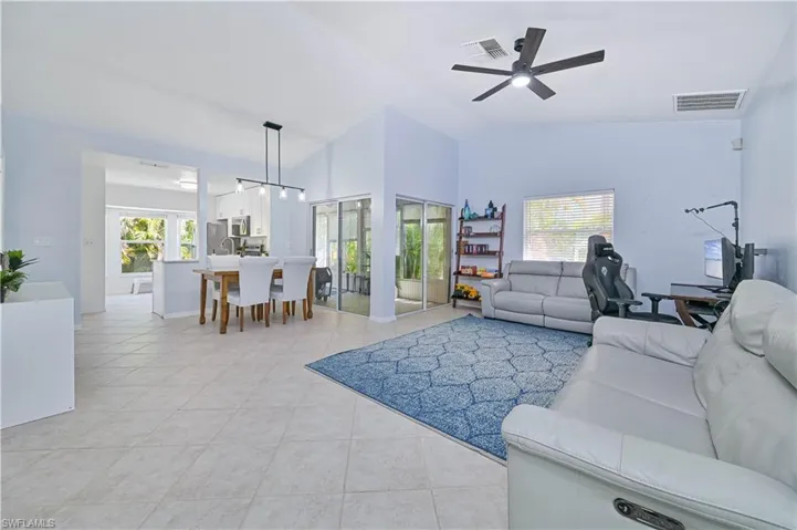 Living room with light tile patterned floors, ceiling fan, and visible vents