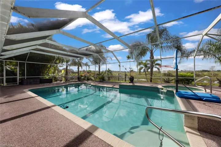 View of swimming pool featuring glass enclosure and a patio area