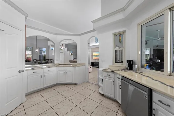 Kitchen featuring crown molding, white cabinetry, and stainless steel dishwasher