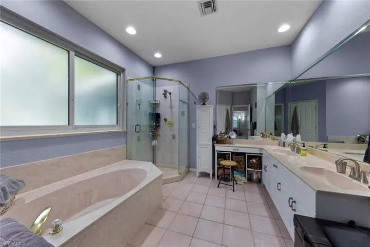 Bathroom featuring independent shower and bath, vanity, and tile patterned floors