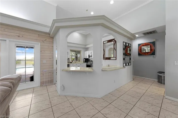 Kitchen with wood walls, ornamental molding, and kitchen peninsula