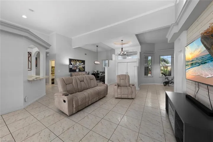 Living room with crown molding and a chandelier