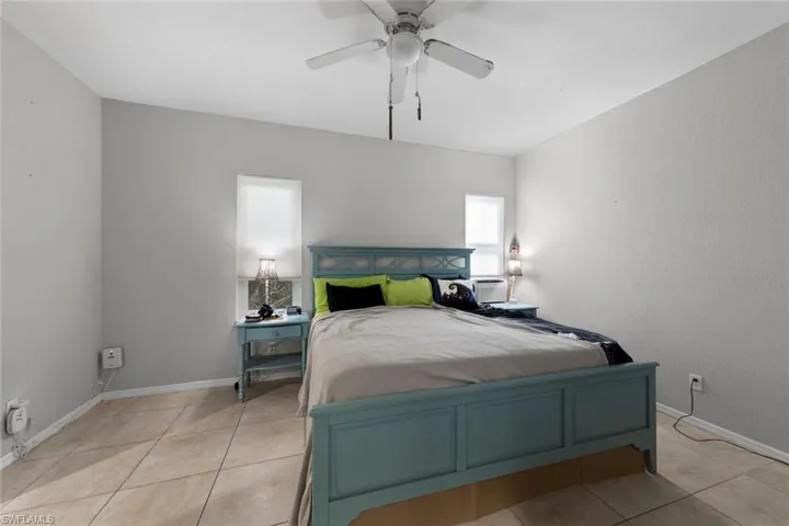 Tiled bedroom featuring ceiling fan