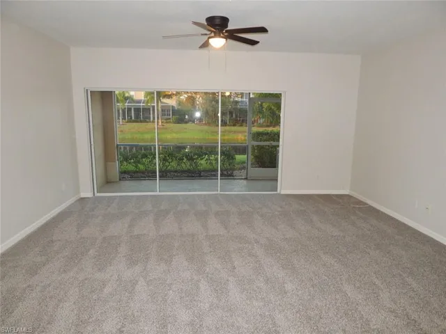 Living room with healthy amount of natural light, a ceiling fan, and light colored carpet