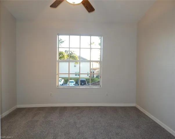 Carpeted guest bedroom with baseboards and ceiling fan