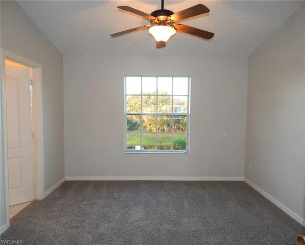 Master bedroom featuring dark colored carpet and a ceiling fan