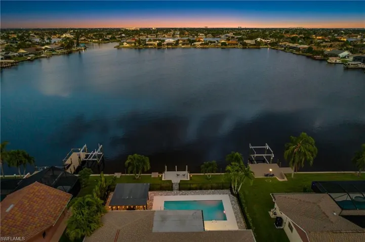 Aerial perspective of suburban area featuring a pool area and a large body of water