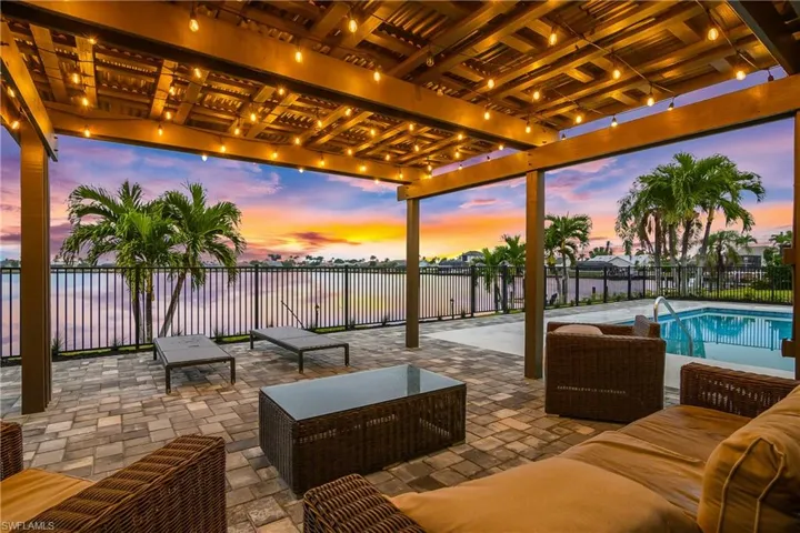 Patio terrace at dusk featuring a fenced backyard, a patio area, an outdoor hangout area, and a water view