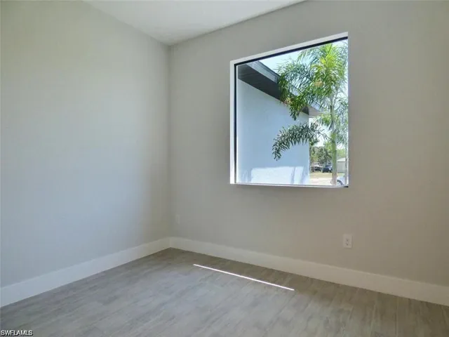Spare room featuring hardwood / wood-style floors and plenty of natural light