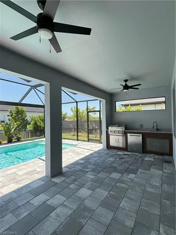 View of swimming pool featuring sink, area for grilling, and ceiling fan
