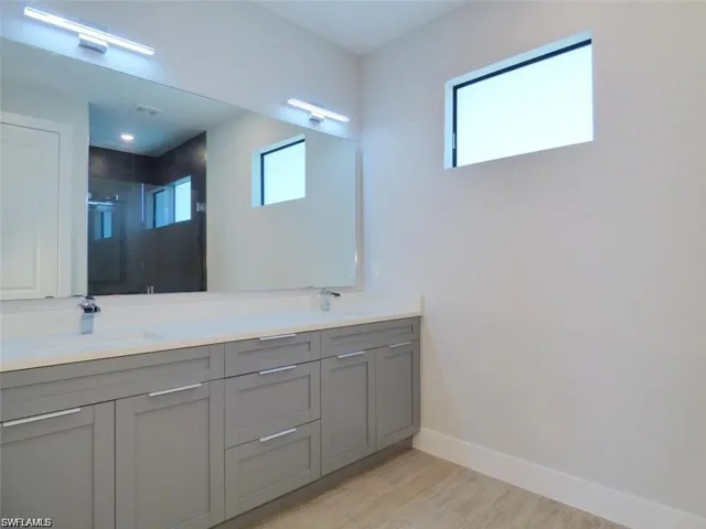 Bathroom featuring hardwood / wood-style flooring, double sink, and oversized vanity