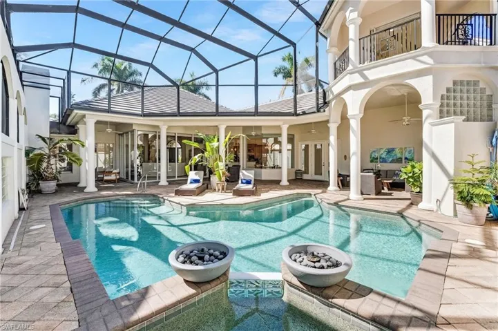 Step into your private oasis on the expansive covered lanai, perfect for year-round entertaining, overlooking a sparkling turquoise pool and spa, set on a pavered deck, and complemented by a fully equipped gourmet outdoor kitchen—resort living at its finest.