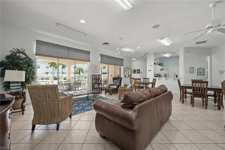 Living room with light tile patterned flooring and ceiling fan