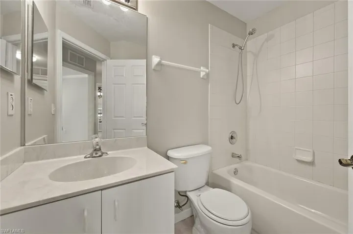 Full bathroom with vanity, toilet, and tiled shower / bath combo