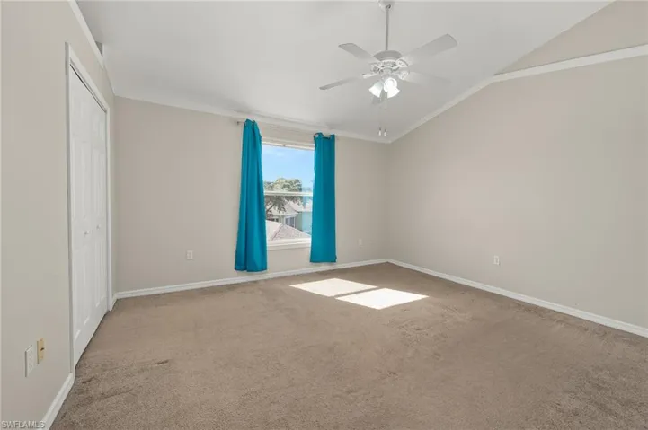 Unfurnished room with lofted ceiling, ornamental molding, light colored carpet, and ceiling fan