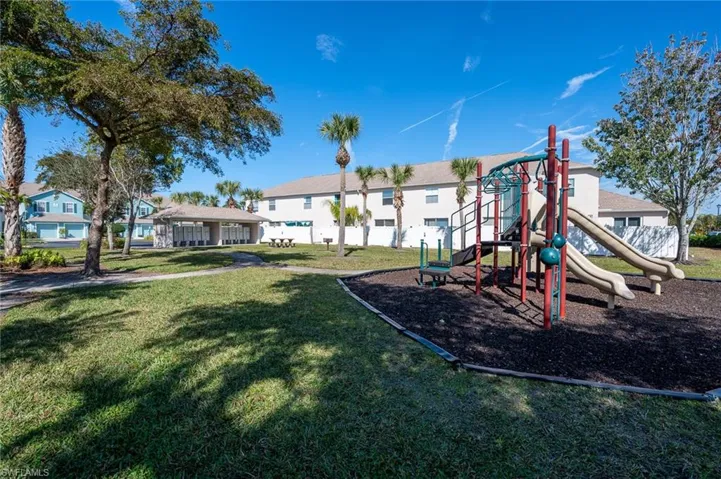 View of jungle gym featuring a lawn