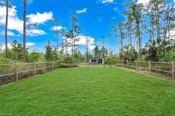 Expansive green lawn surrounded by a split-rail fence