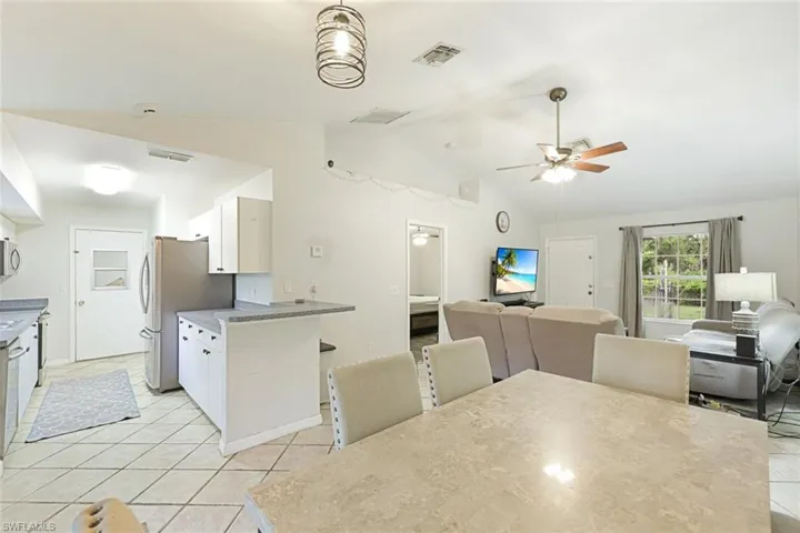 Open concept living area with vaulted ceilings and tile flooring