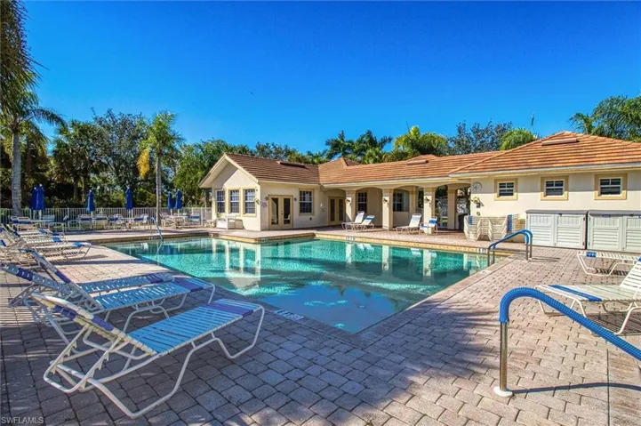 Expansive swimming pool with integrated entry handrails, surrounded by a paver deck