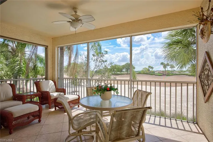 Screened lanai featuring tile flooring, a ceiling fan, and extensive views of the outdoor landscape