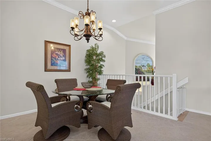 Open-concept dining area featuring a vaulted ceiling and a decorative chandelier