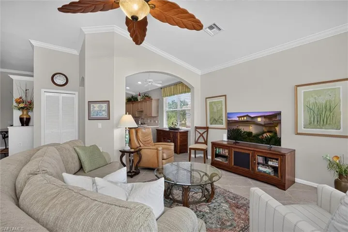 Spacious living area featuring neutral wall tones and crown molding