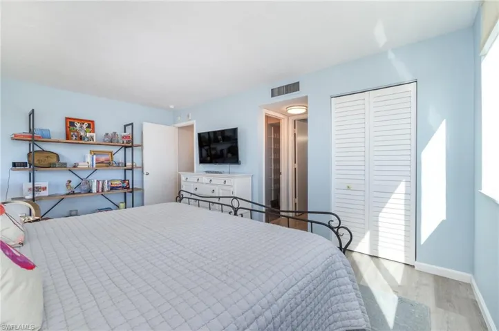 Bedroom with wood finished floors and a closet