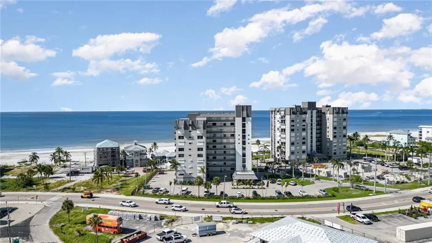 Drone / aerial view of unending shoreline and apartment complex