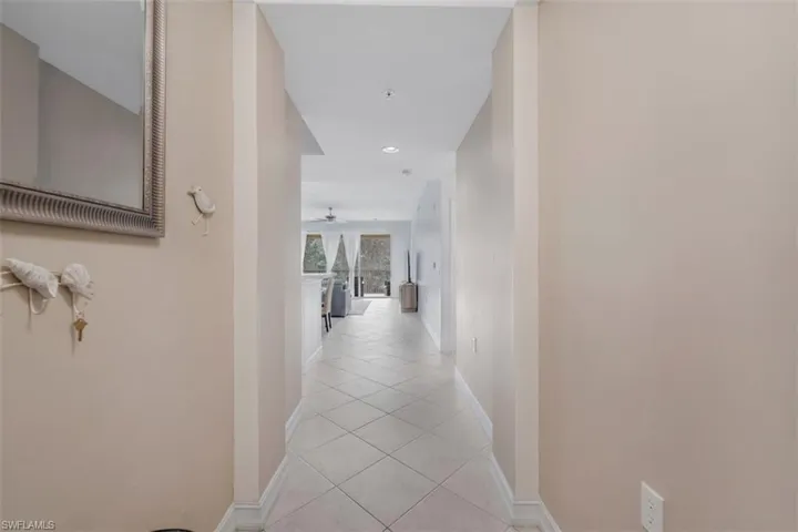 Corridor with light tile patterned floors and recessed lighting