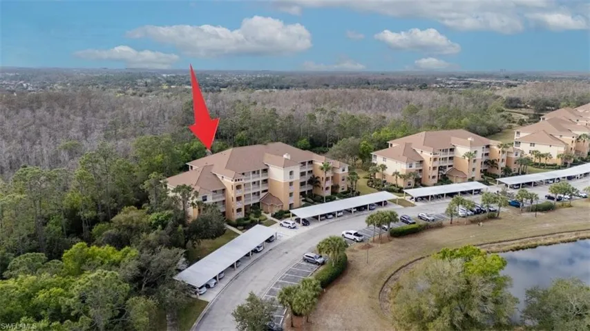 Aerial overview of property's location featuring a heavily wooded area and a nearby body of water