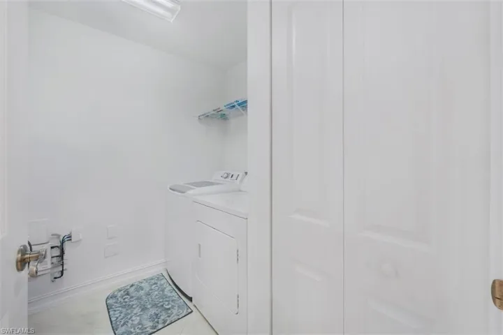 Laundry room with washer and dryer and tile patterned flooring