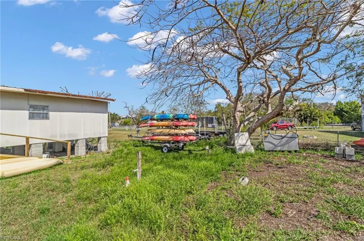 View of yard with fence & extra lot in the distance