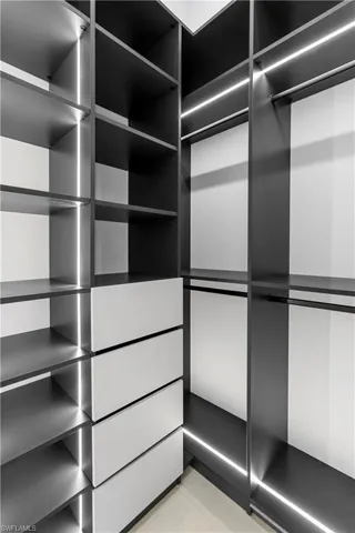 Custom closet system featuring integrated lighting, multiple shelving units, and built-in drawers