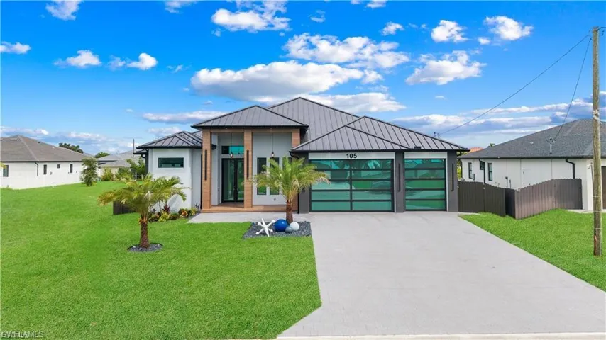 Contemporary exterior with a metal roof, two-car garage with frosted glass doors, and a concrete driveway
