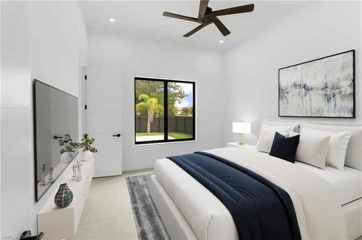 Bedroom featuring a black-framed window, a dark ceiling fan, light-toned flooring, a flat-panel door with black hardware, and an accent wall