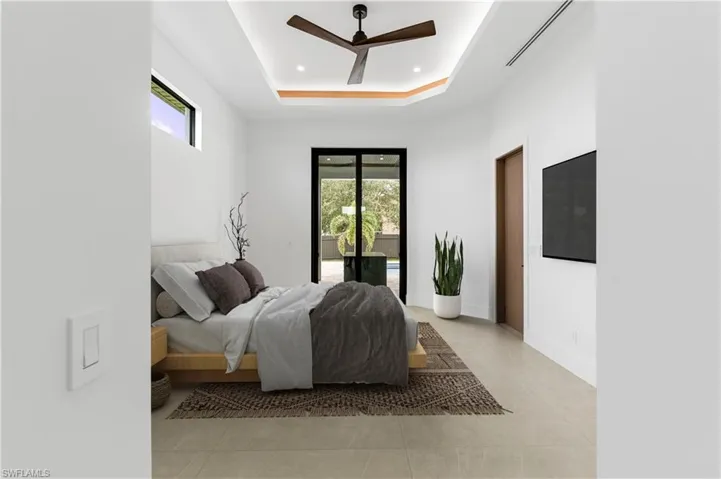 Bright interior space featuring a tray ceiling with recessed lighting and a ceiling fan