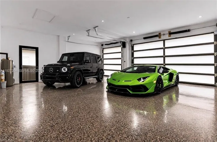 Spacious garage featuring polished speckled concrete flooring, white walls, and two modern sectional garage doors