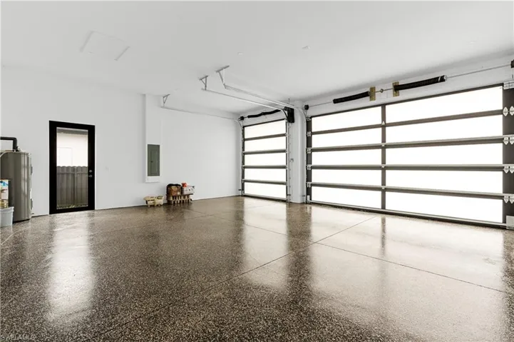 Two modern garage doors with frosted panels, high ceilings, and a concrete floor with a polished finish