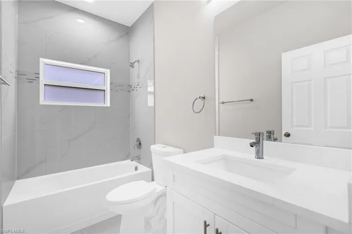 Bathroom featuring vanity and washtub / shower combination