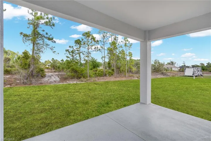 View of grassy yard featuring a patio area